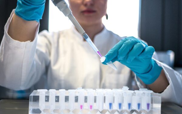 A scientist dropping liquid into test tubes